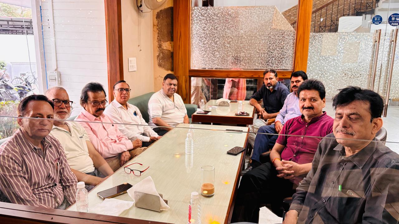 Alt Text: A group of senior journalists and editors discussing important city issues in a meeting.